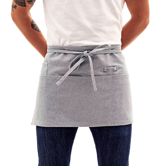 A person wearing a blue waist apron with a tie and pockets, designed for kitchen use.
