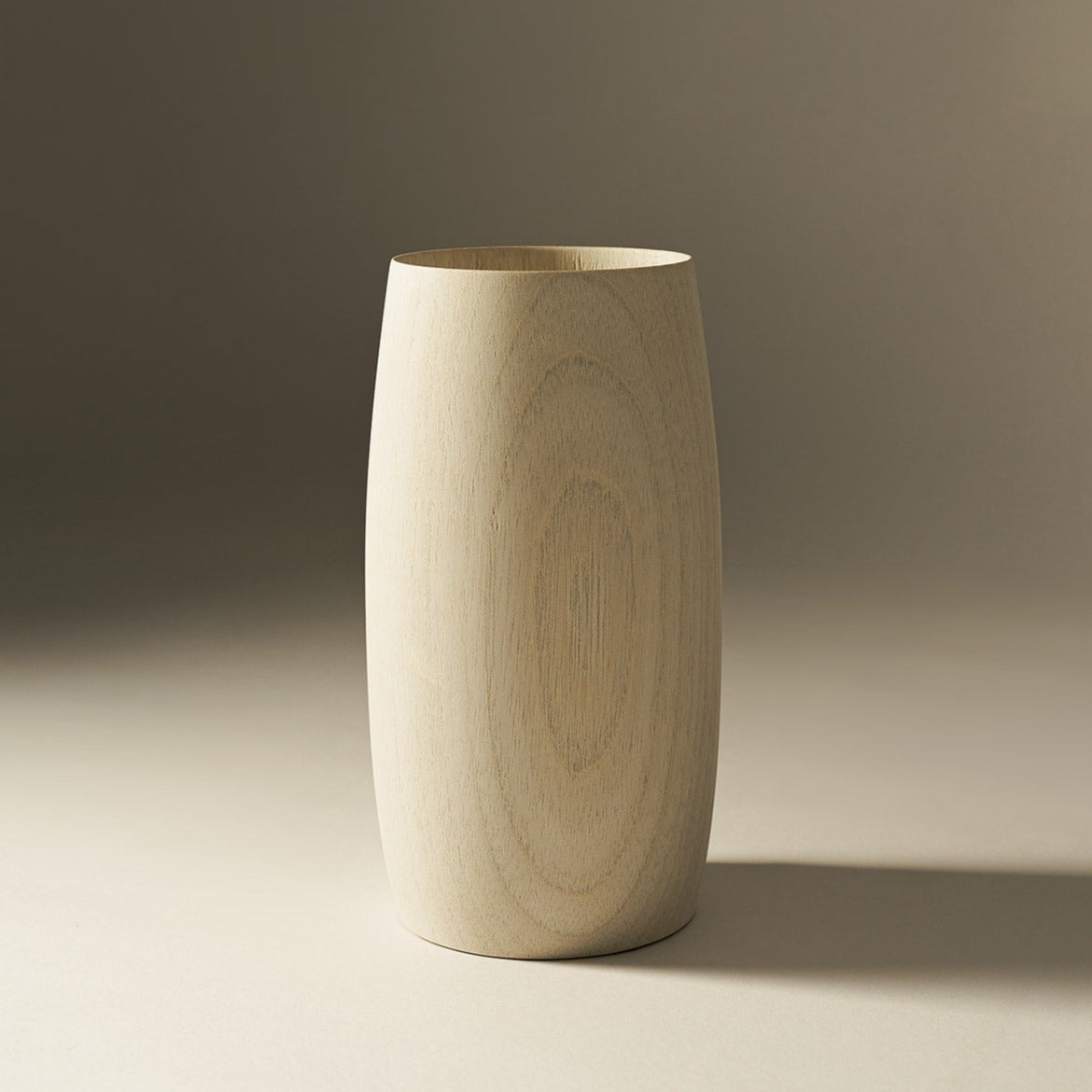 A beige, cylindrical ceramic vase with a subtle, natural wood finish.