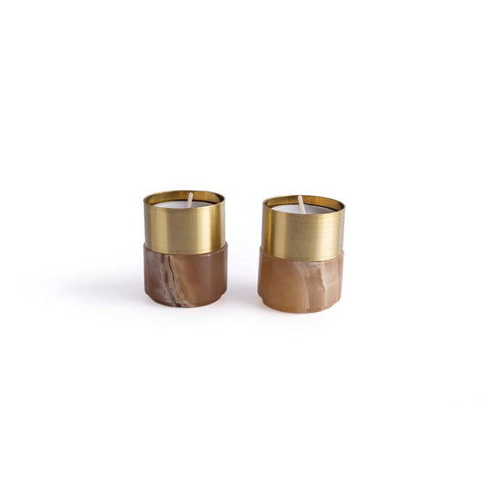 A pair of brass candle holders with amber alabaster coloring, featuring a satin brass shade on top.