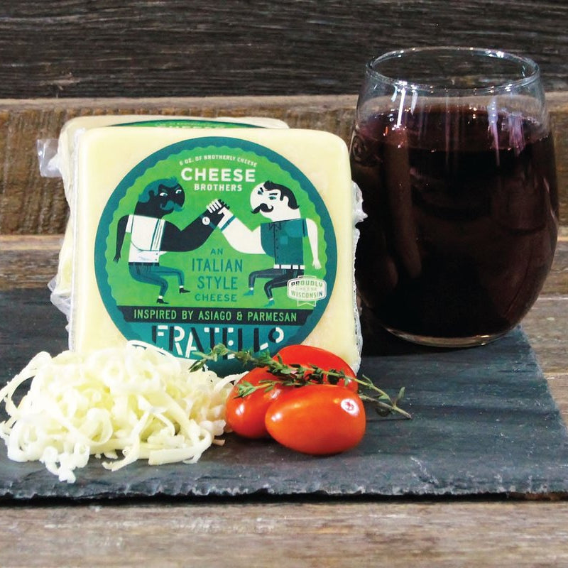Cheese package with a glass of red wine dark and tomatoes on a wooden surface