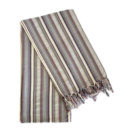 A striped Turkish towel in gray, blue, and beige, with hand-knotted tassels.