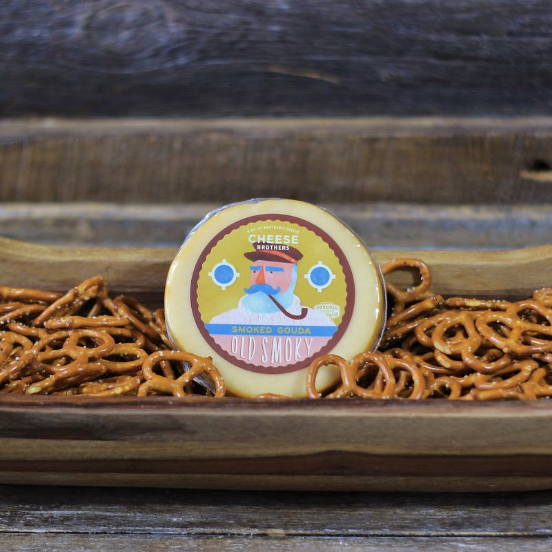 Wooden bowl with pretzels and a decorative cookie on a wooden surface