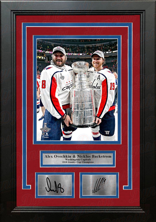 Framed photograph of two hockey players holding a Stanley Cup with signatures and team logos.