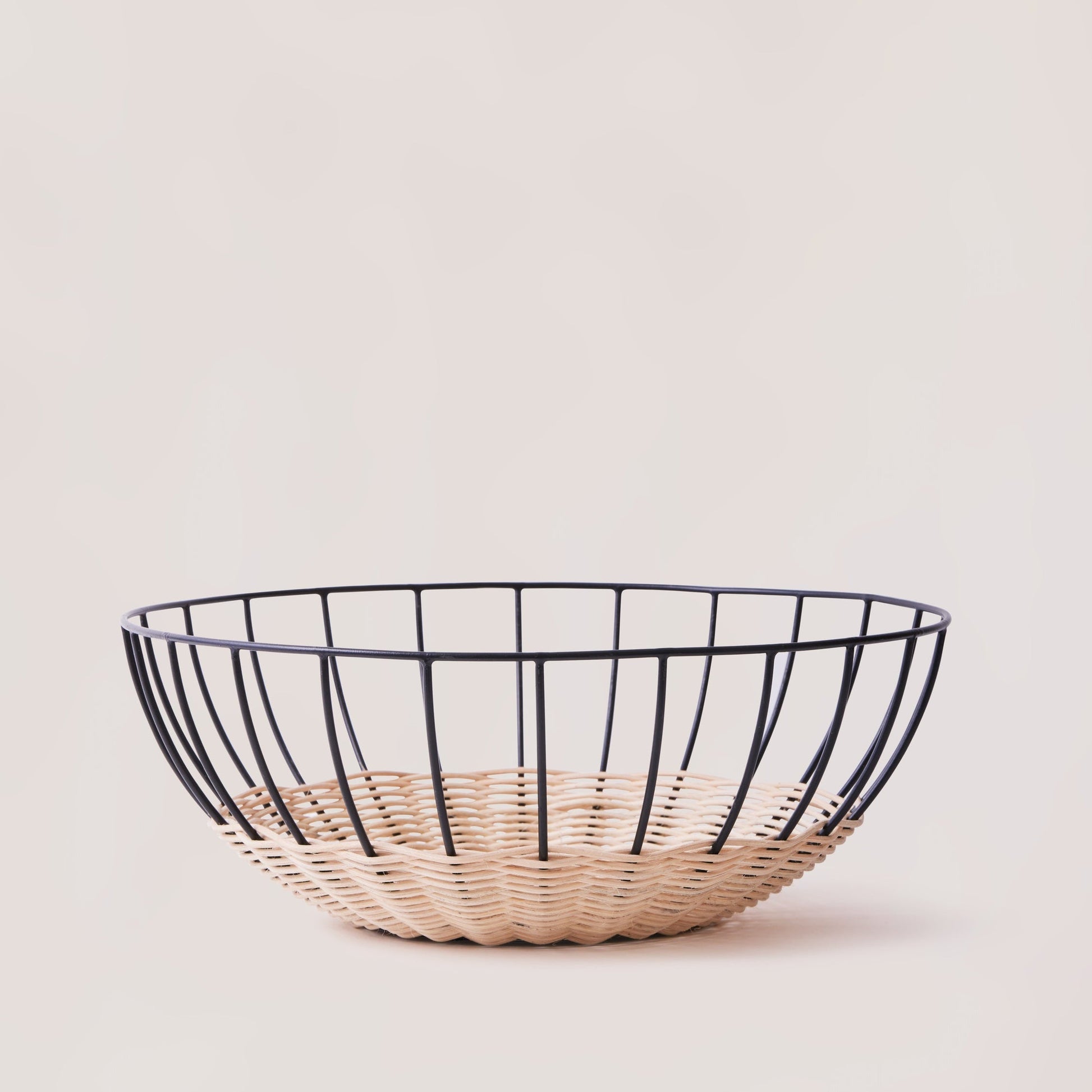 A woven rattan basket with a powder-coated iron frame, featuring a open, airy design, displayed against a neutral background.