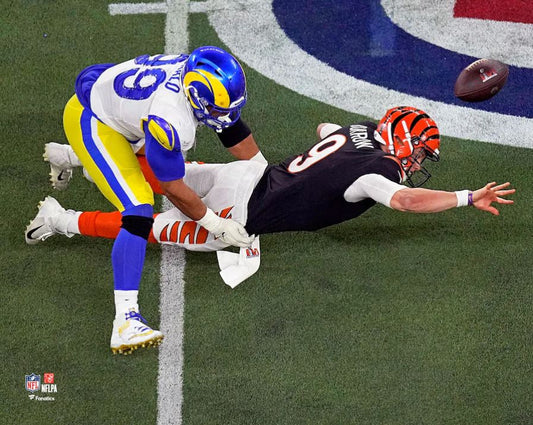 Two football players in action on a field with a visible NFL logo.