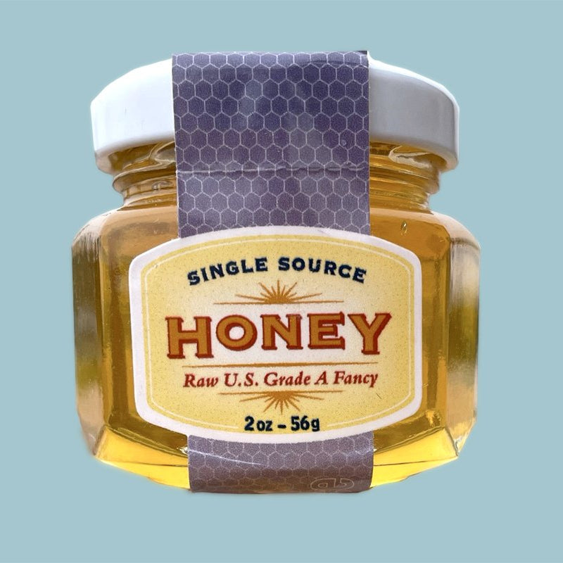 Jar of honey with a label on a light blue background