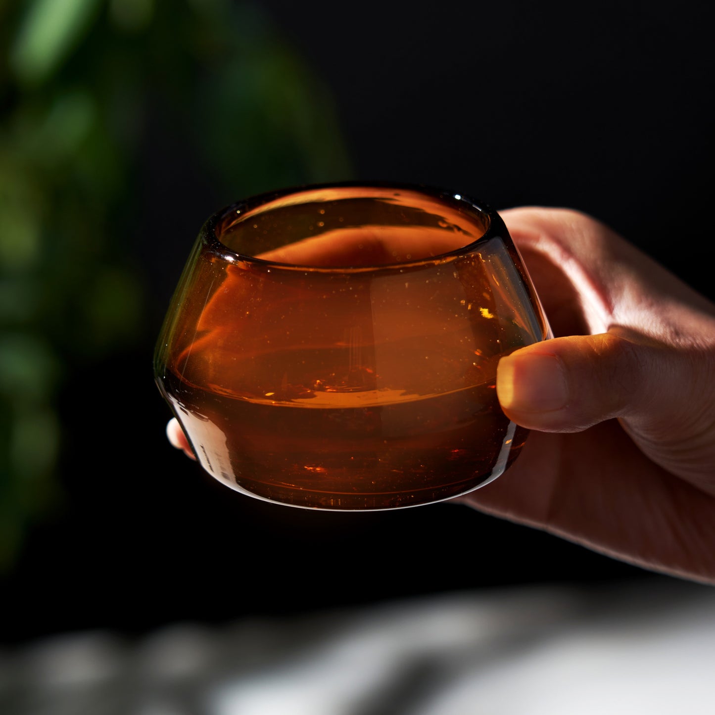 Hand holding copita glass with amber liquid 